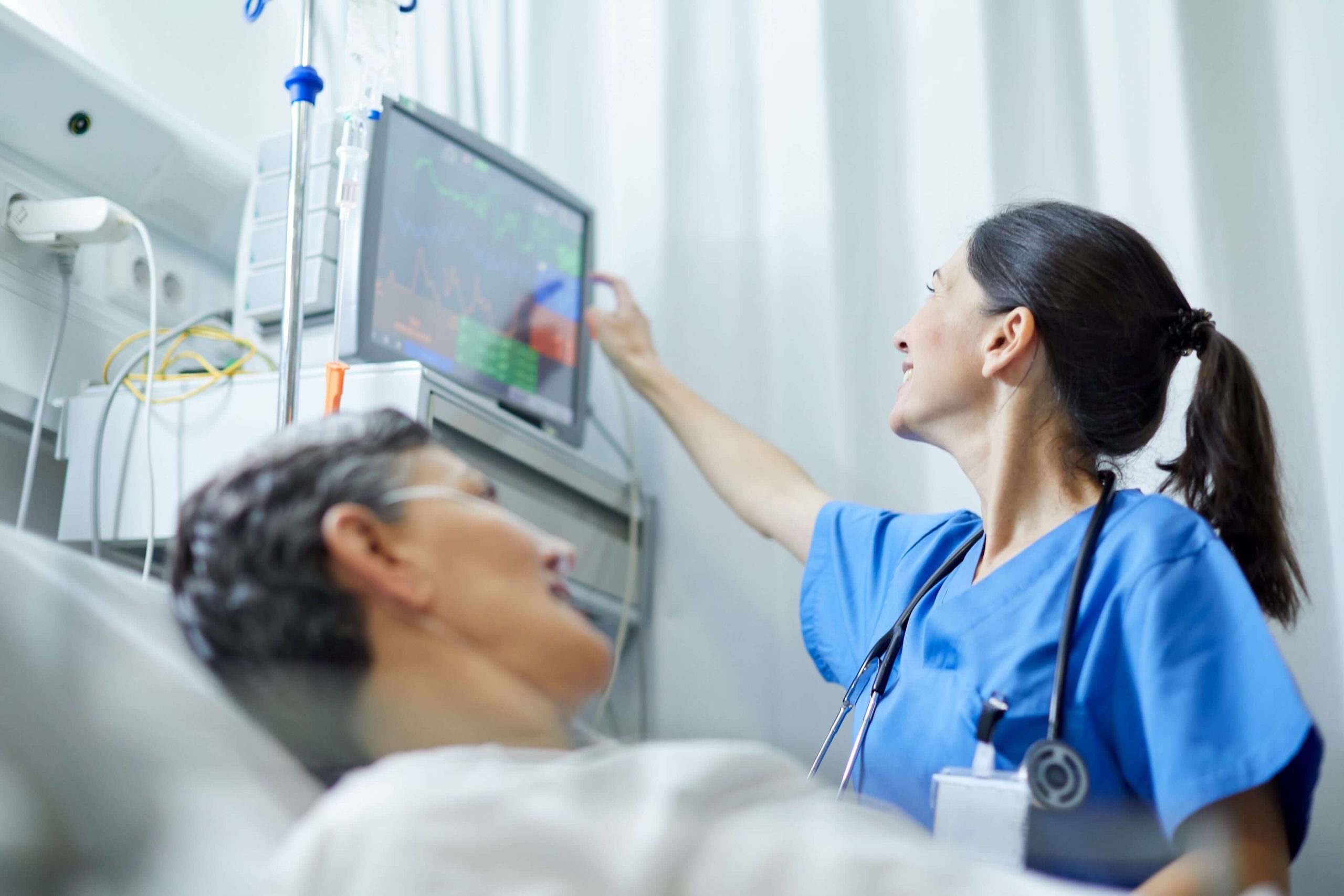 ECMO specialist reviewing live vitals on a patient in critical care, ensuring 24/7 expert monitoring and precision support.