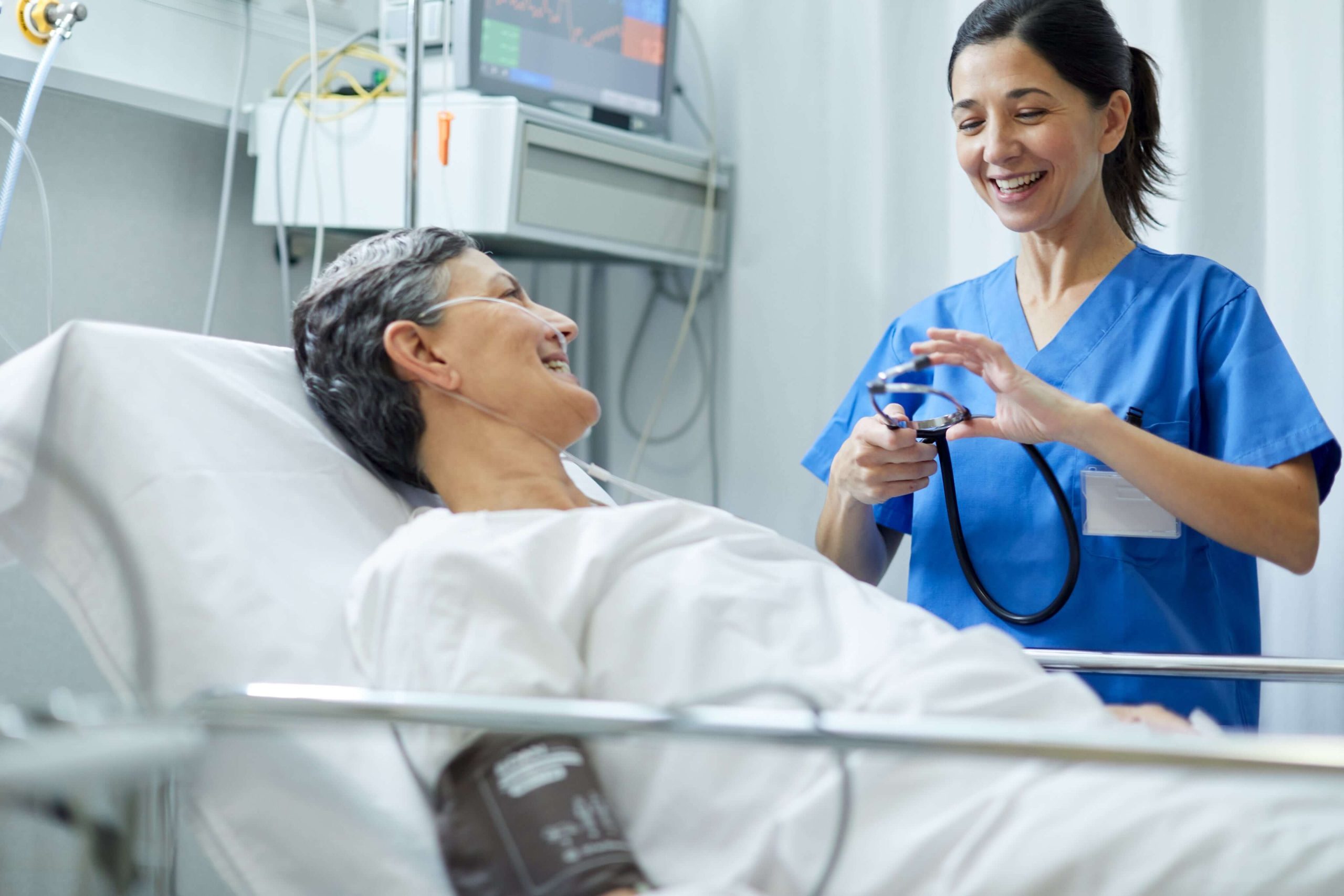 Clinician supporting a smiling patient during monitoring—delivering confidence and connection at the bedside.