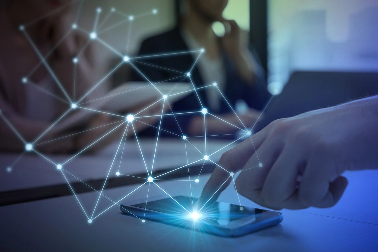Hand tapping a smartphone with a glowing digital network overlay—symbolizing data connectivity, innovation, and real-time communication.