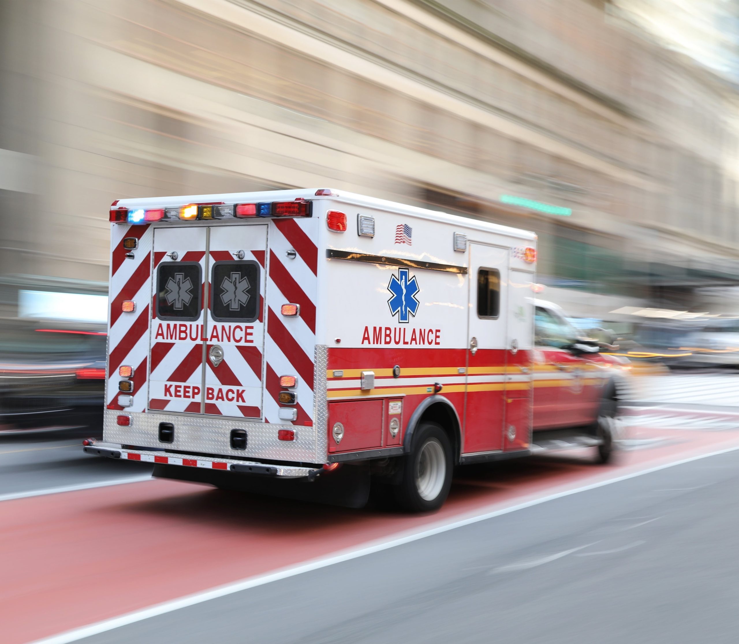 Ambulance in rapid motion through city streets, symbolizing ground-level ECMO transport readiness.